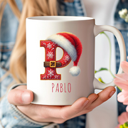 Taza personalizada de Navidad con inicial y gorro de Papá Noel.