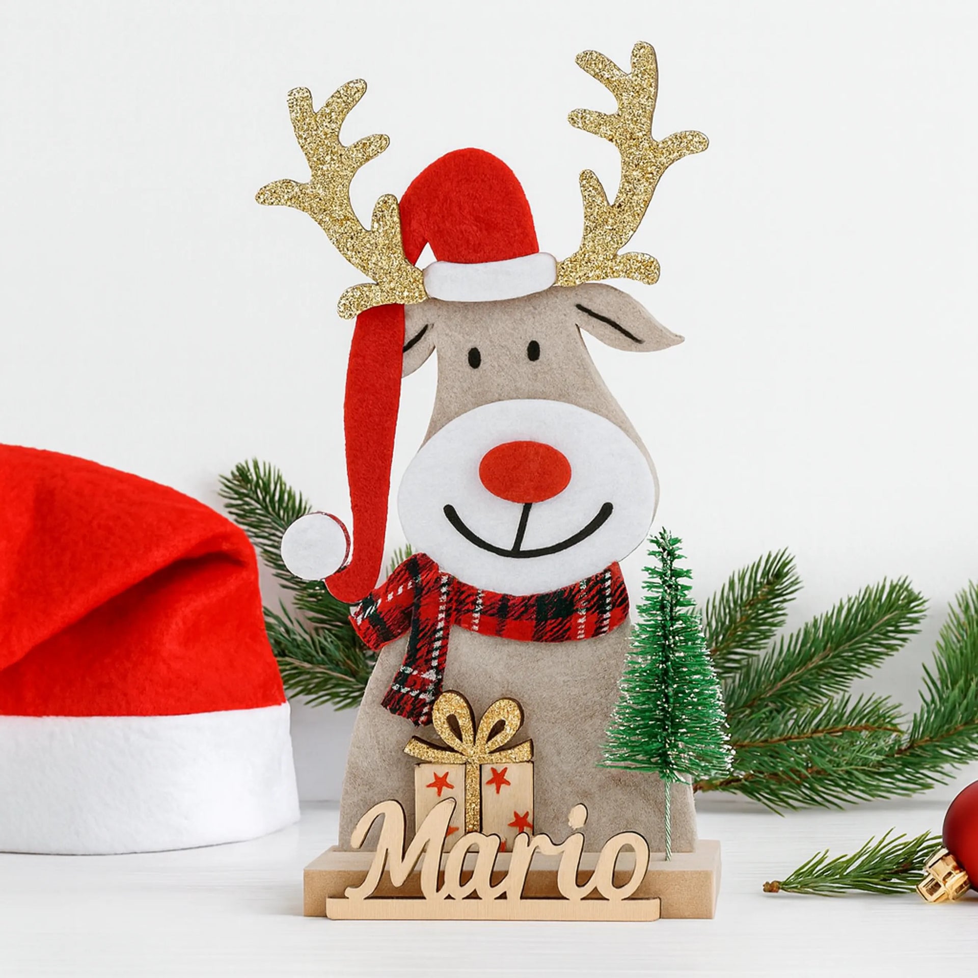 Reno navideño de fieltro con base de madera, gorro de Papá Noel y nombre tallado, detalle artesanal de Navidad personalizado con árbol y regalo.
