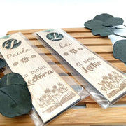 Detalle de lectura personalizado: marca páginas de madera grabada con cinta de gasa elegante.