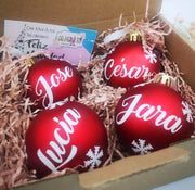 Adorno de Navidad de bola roja brillante con nombre en dorado, ideal para árboles temáticos.