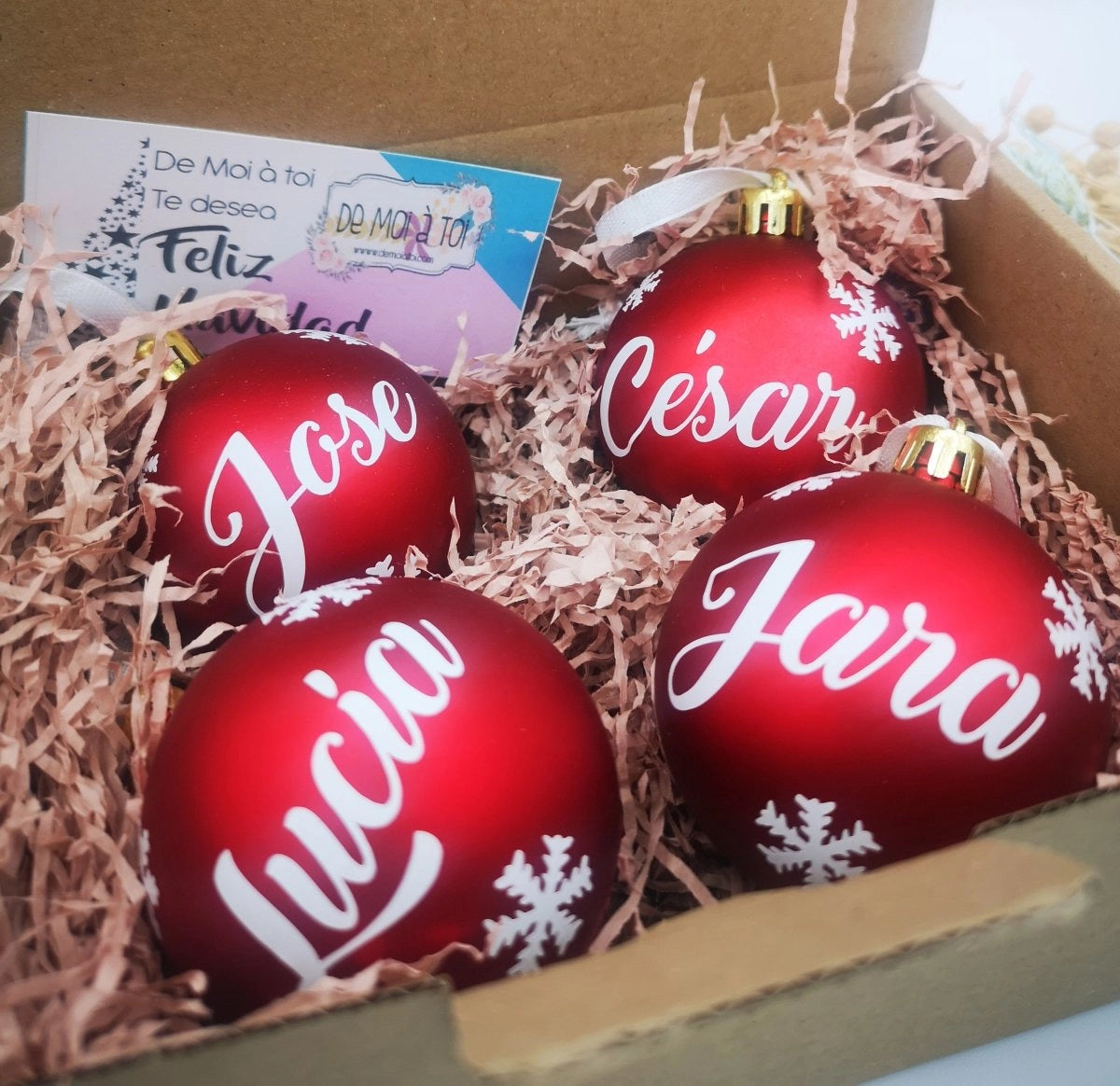 Adorno de Navidad de bola roja brillante con nombre en dorado, ideal para árboles temáticos.
